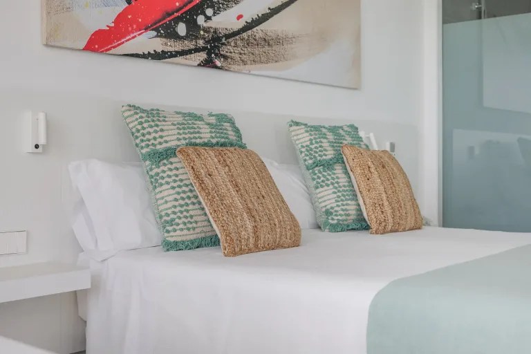 hay una cama con dos almohadas y un cuadro en la pared cama blanca fotografia de diseno de interiores