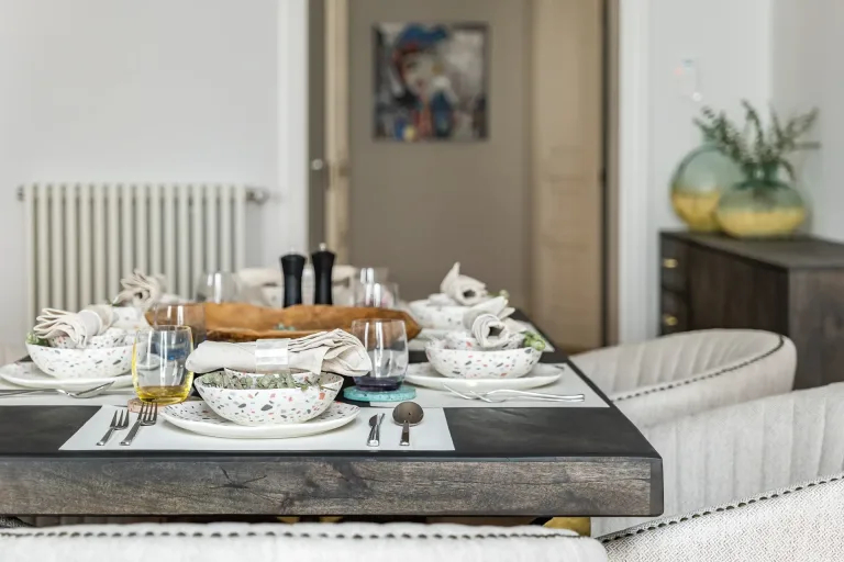 mesa de comedor de madera con platos y vajilla en el interior de una sala de estar