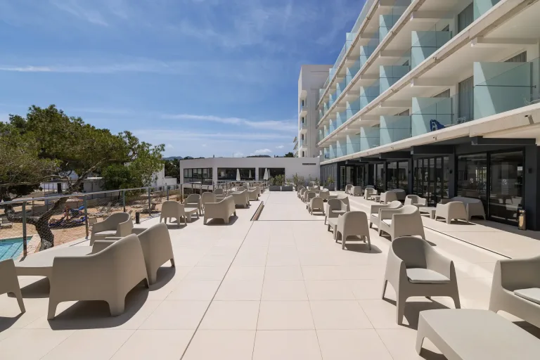 mesas y sillas en un patio con vista a una piscina y un hotel terraza hermosa terraza fotografia exterior costa del sol