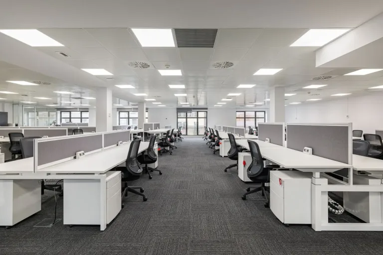 muchos escritorios y sillas en la oficina abierta moderna con mucha luz