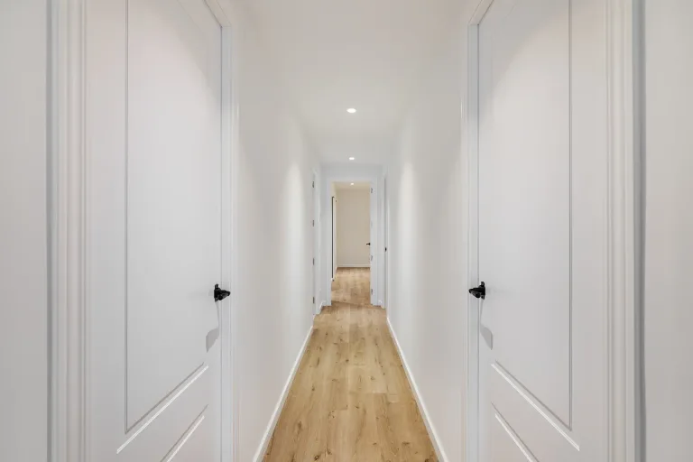 pasillo largo con paredes blancas y suelo de madera pasillo estrecho