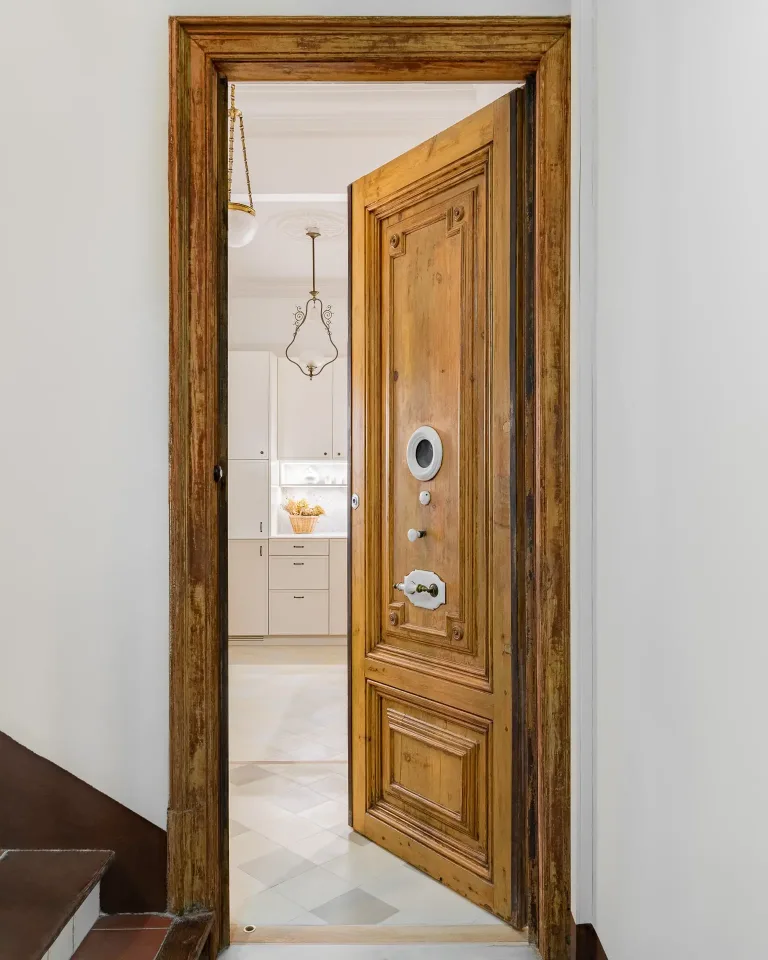 puerta que conduce a un apartamento con puerta de madera y suelo de baldosas
