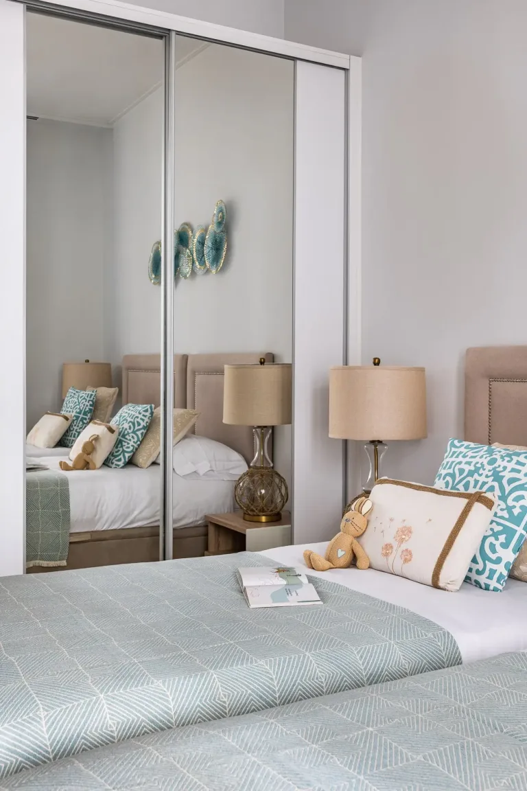 puertas de armario con espejos en un dormitorio con una cama y una mesita de noche fotografia de diseno de interiores