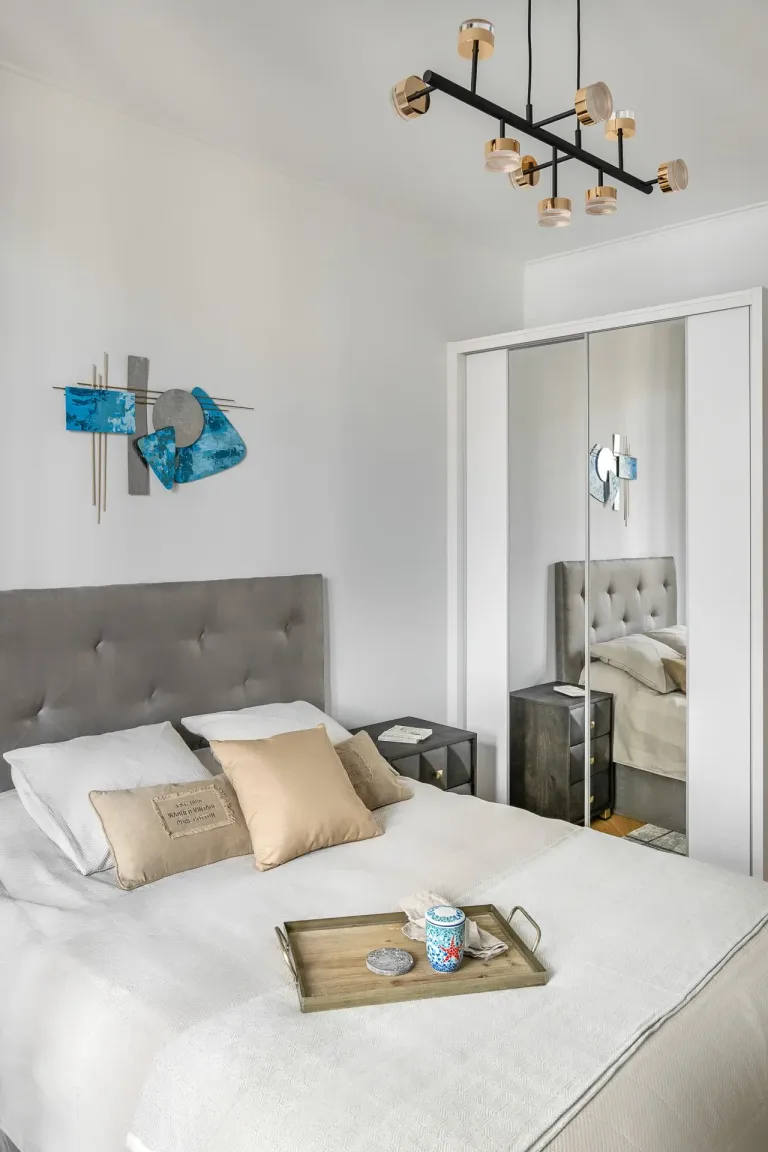 una cama con una bandeja en un dormitorio esquemas de color plateado y azul iluminacion plana neutra