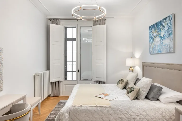 una cama en un dormitorio con una imagen en tonos azules en la pared apartamento moderno renovado