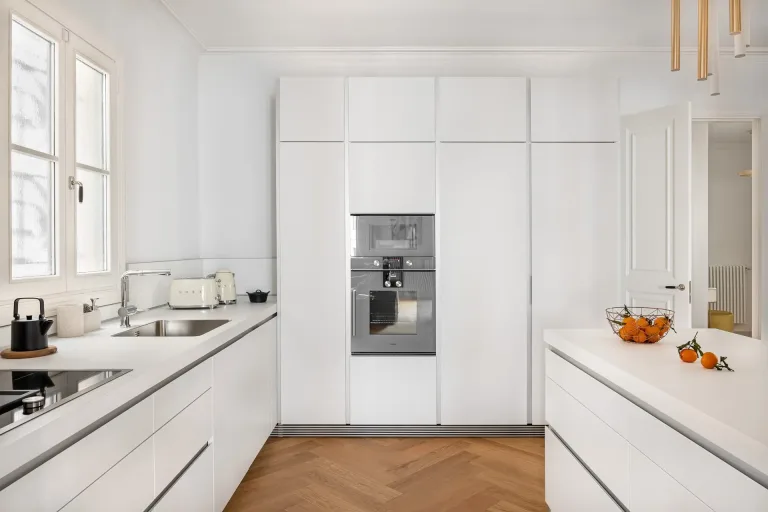 una cocina moderna con horno fregadero y muebles blancos diseno de cocina minimo