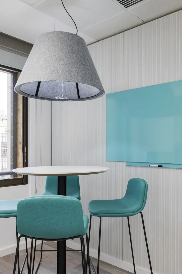 una mesa con sillas y una lampara colgando sobre ella interior de oficina moderno