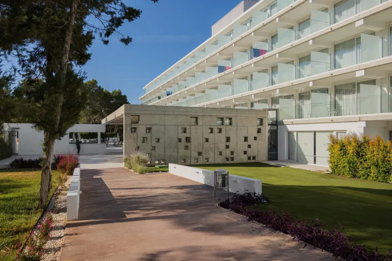 una pasarela que conduce a un hotel con cesped verde edificios modernistas