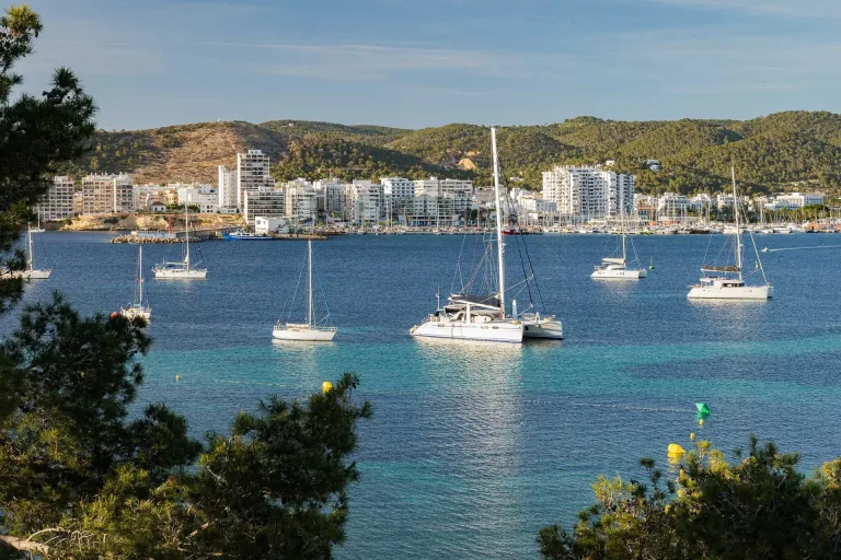 varios veleros estan anclados en el agua cerca de una ciudad ibiza veleros costa blanca