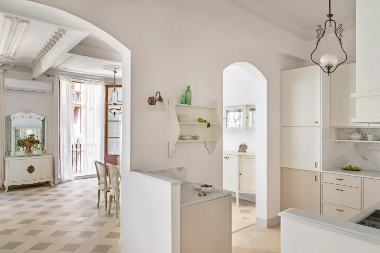 vista de una cocina y una sala de estar con elementos decorativos en un interior clasico de apartamento renovado