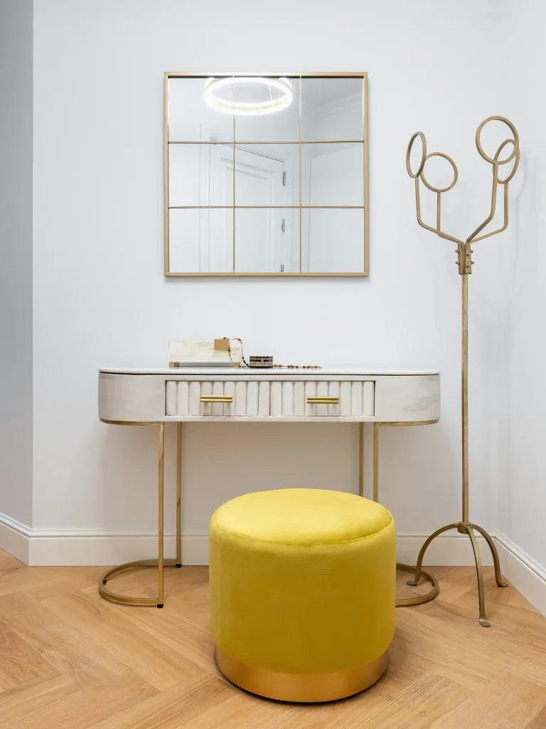 yellow pouf in front of a mirror in the hallway of a modern apartment