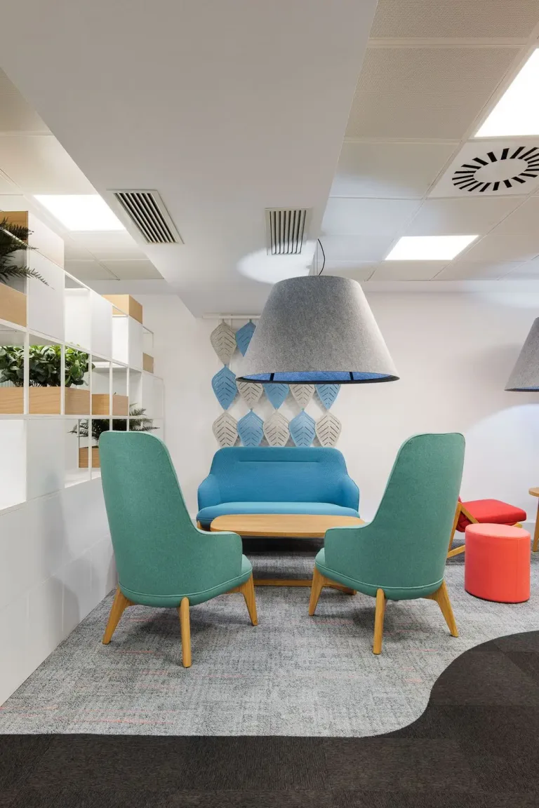 zona de salon en una oficina moderna con muebles de colores y lampara grande espacio de diseno creativo