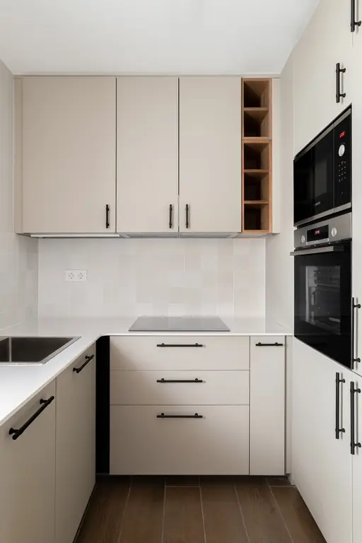 cocina compacta blanca con horno empotrado y tiradores negros