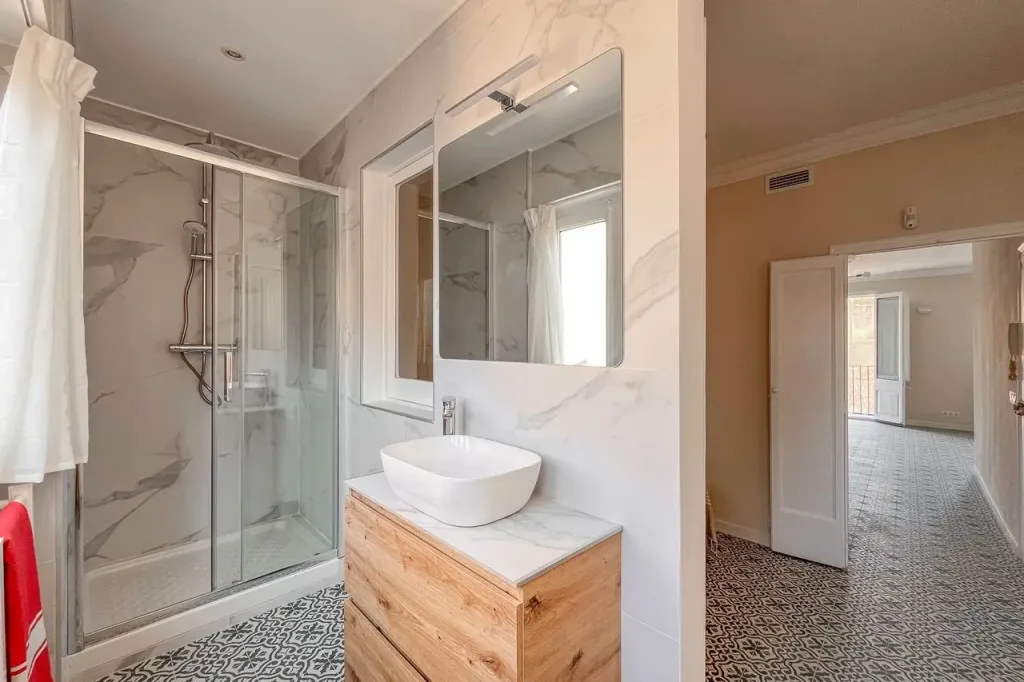 bano con lavabo sobre encimera de madera y espejo
