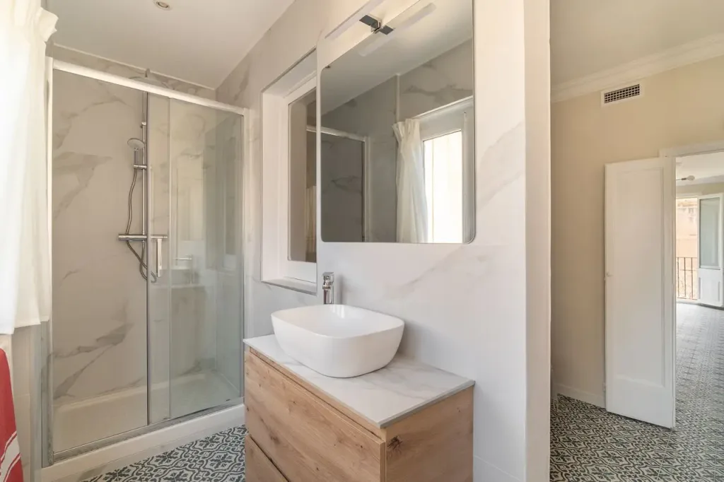 baño moderno con mueble de madera y espejo grande
