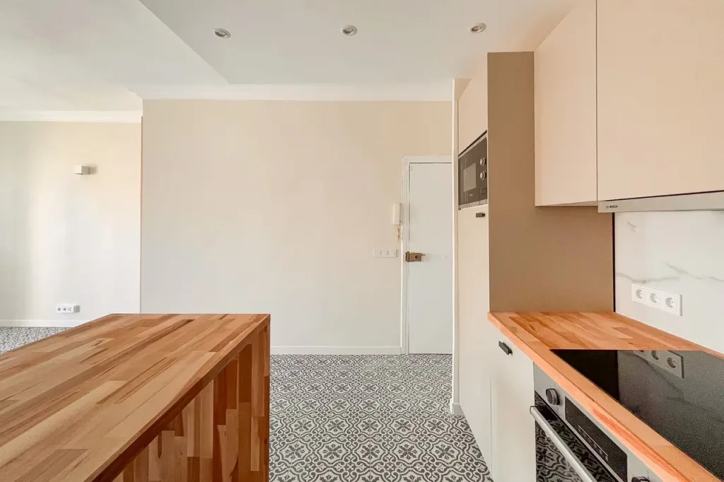 cocina estilo abierto con barra de madera y pared de ladrillo visto