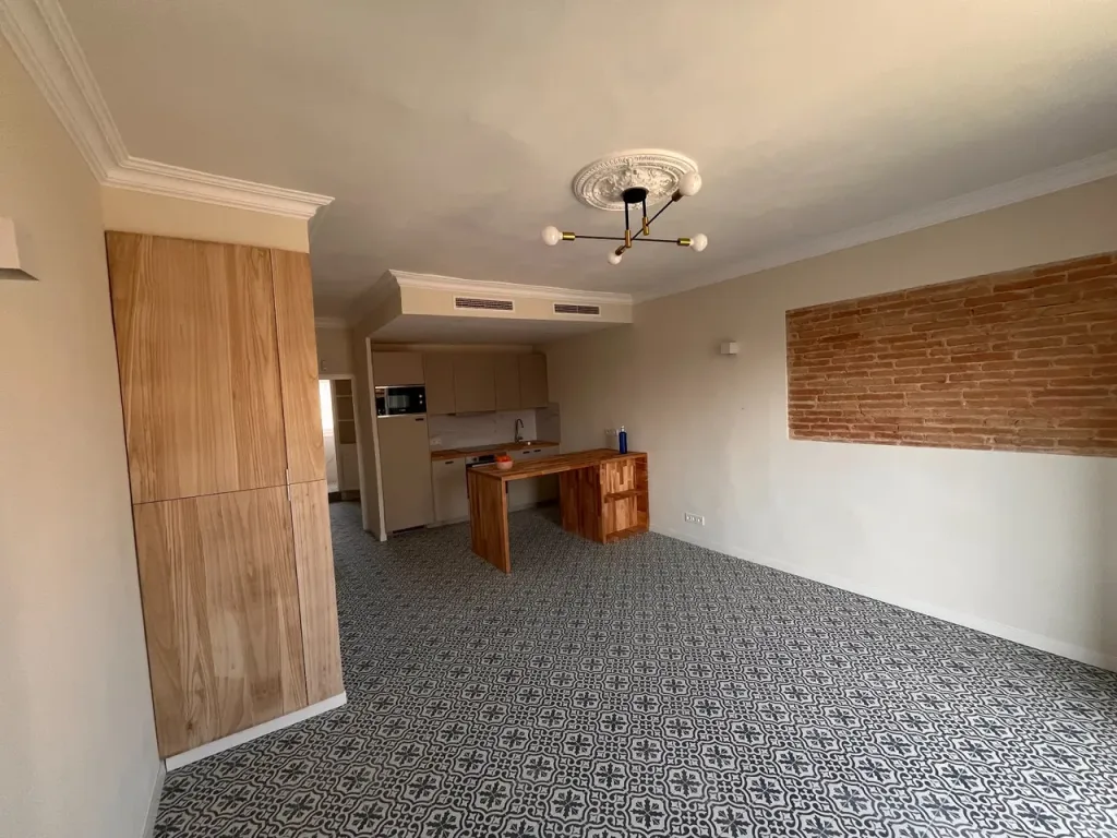 cocina integrada vista desde la sala con muebles de madera y piso de mosaico