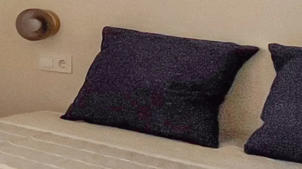 detalle de almohadas negras con textura en habitación clara