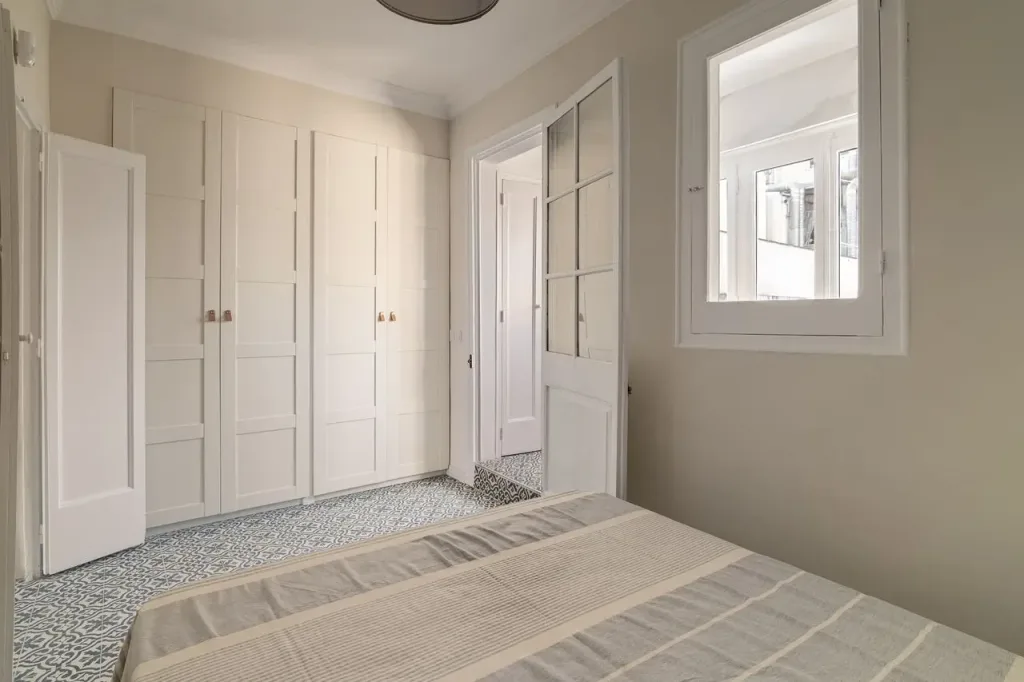 dormitorio con armario blanco y ventana a patio interior
