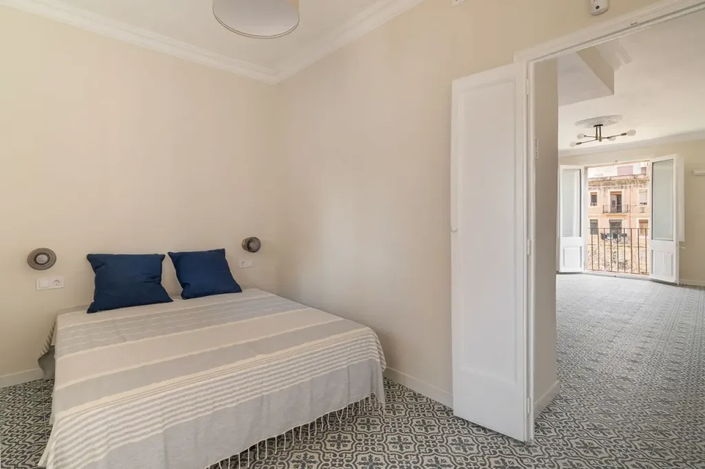 dormitorio espacioso con cama doble y balcon