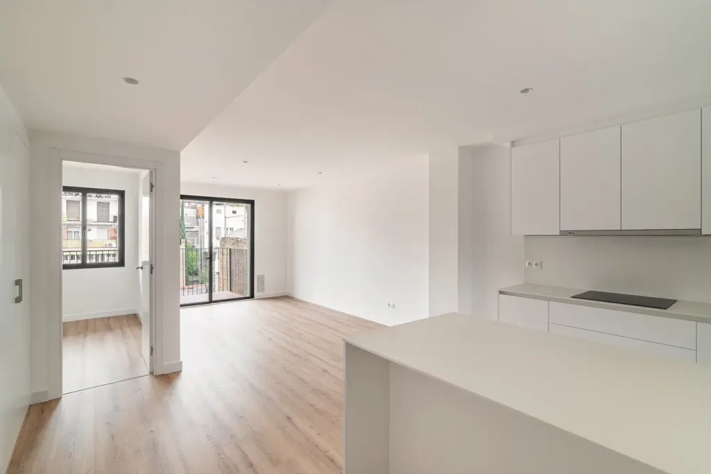Interior de un salon moderno y espacioso con una cocina vacía con suelo de madera
