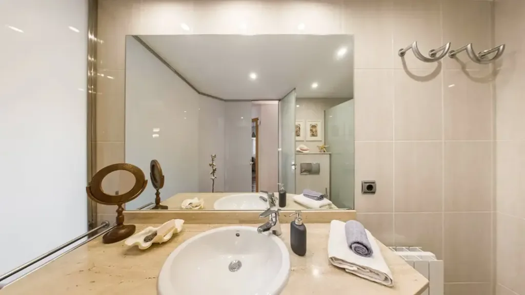 baño bien iluminado con espejo y lavabo