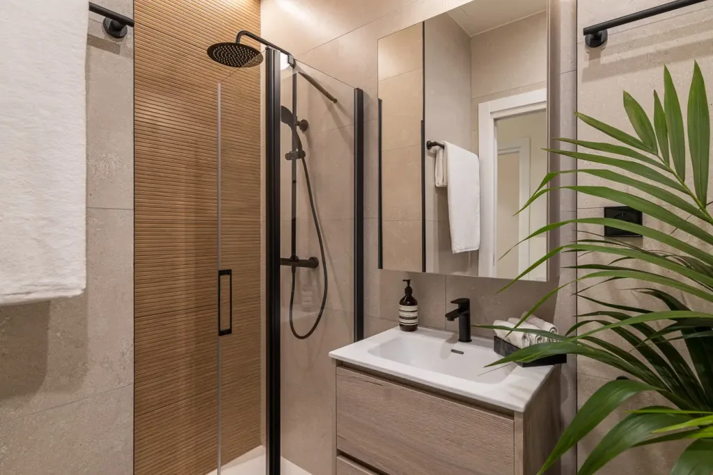 Baño moderno con ducha de cristal y paredes de azulejos beige
