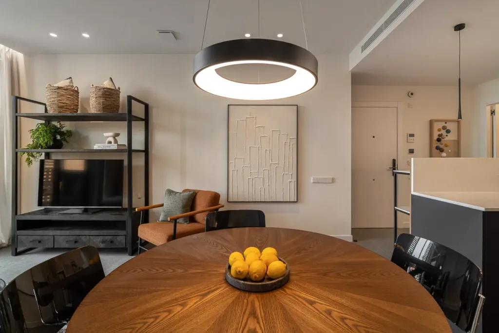 Espaciosa sala de estar con sofá gris y lámpara colgante circular iluminada