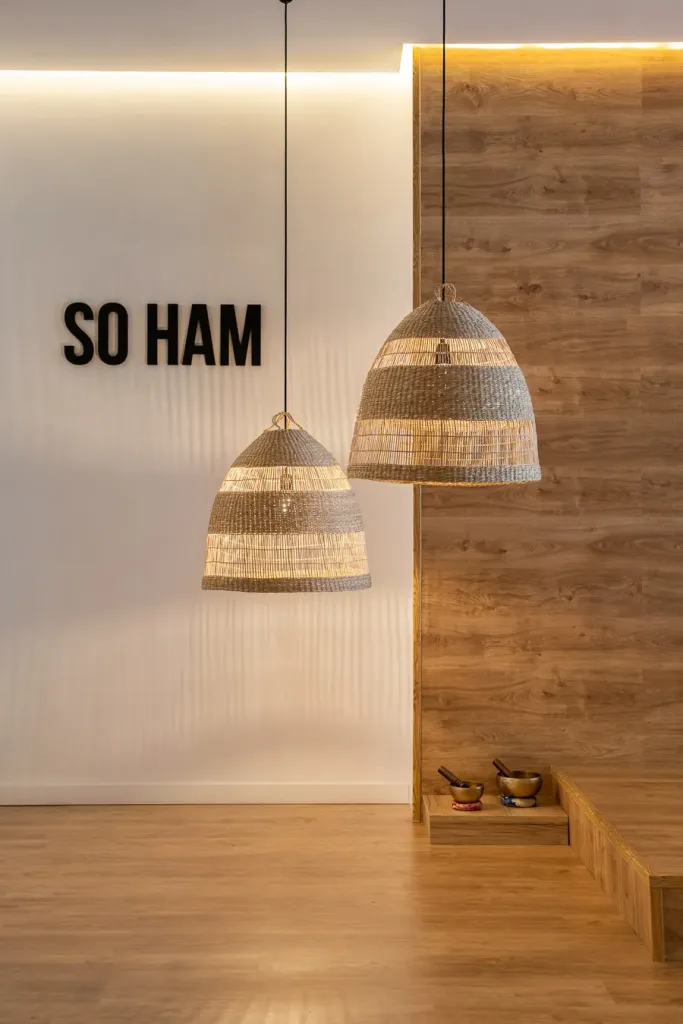 Detalle de lámparas colgantes y pared decorativa con letrero So Ham