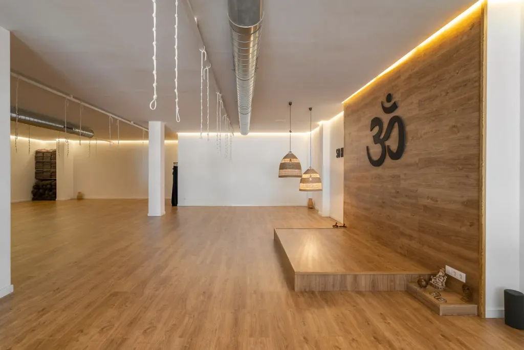 Espacio de yoga amplio con escenario y lámparas colgantes