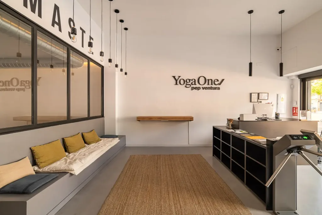 Recepción moderna con iluminación colgante y logotipo del estudio de yoga