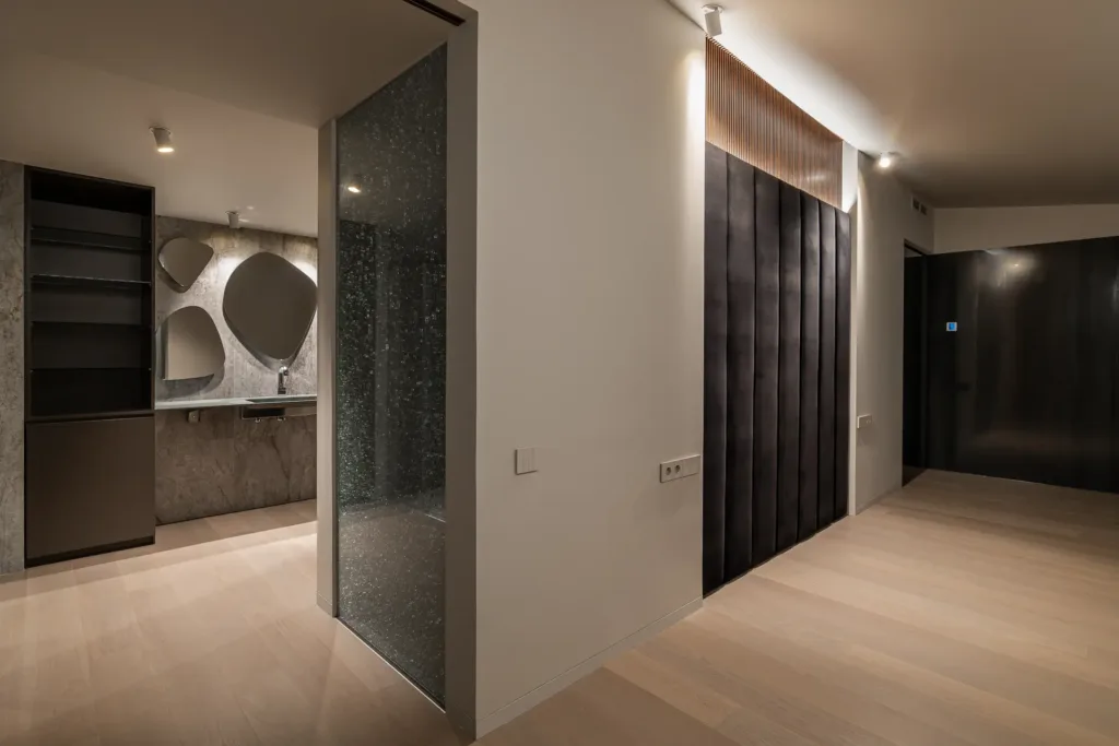 baño moderno con muebles oscuros y espejos irregulares