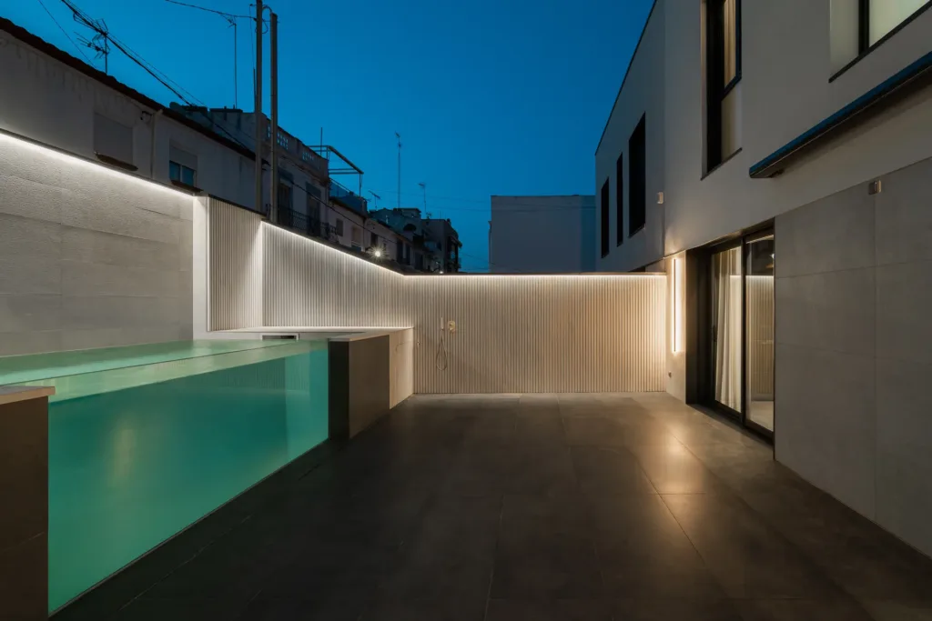 patio moderno con iluminación y piscina