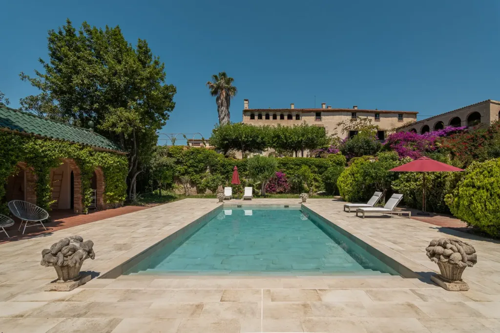 piscina frente a una casa rodeada de vegetación