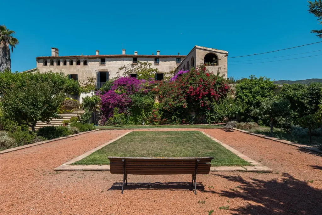 vista frontal de una casa con jardín y flores moradas