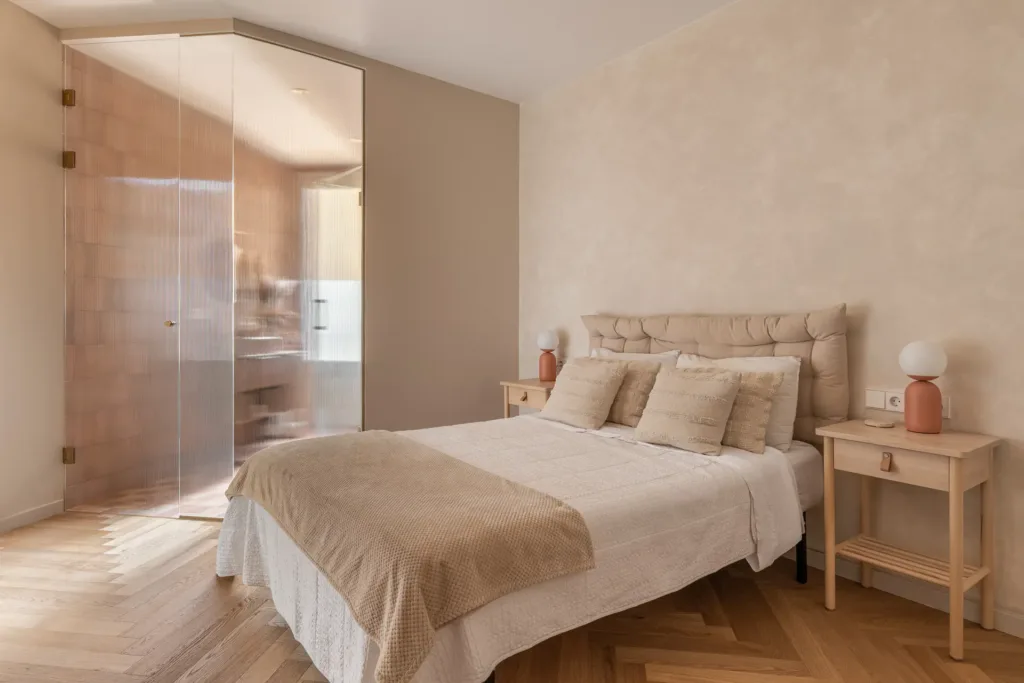 dormitorio con cama y pared de tono suave