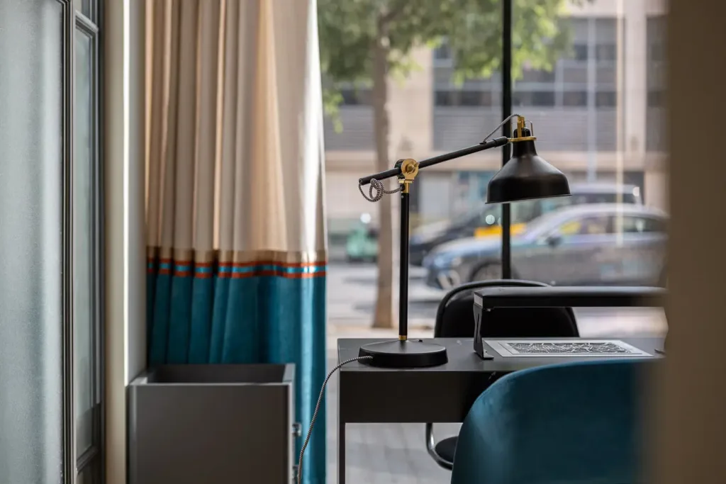 escritorio con lampara de mesa cerca de la ventana