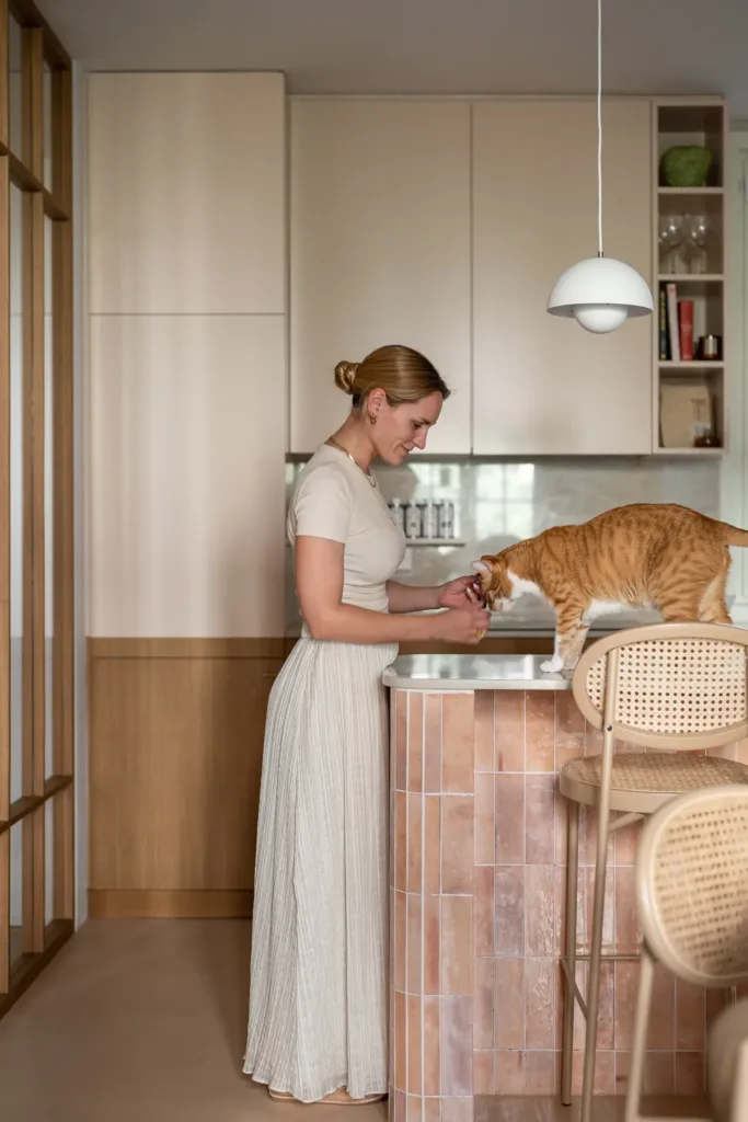 persona alimentando a gato en cocina moderna