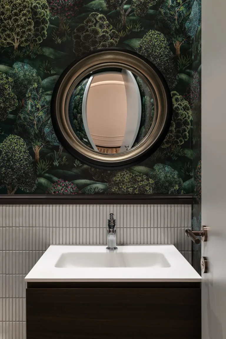 baño con decoración única y espejo circular