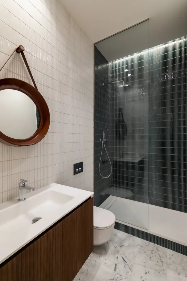 cuarto de baño moderno con ducha de vidrio y lavabo de madera