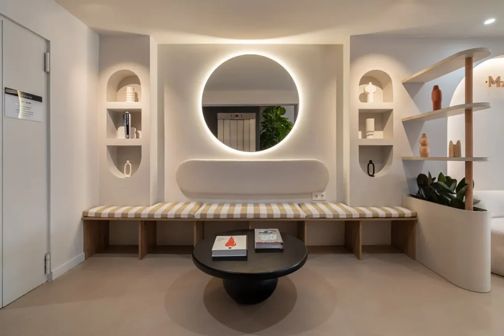 banco con espejo circular y luz suave en un espacio moderno