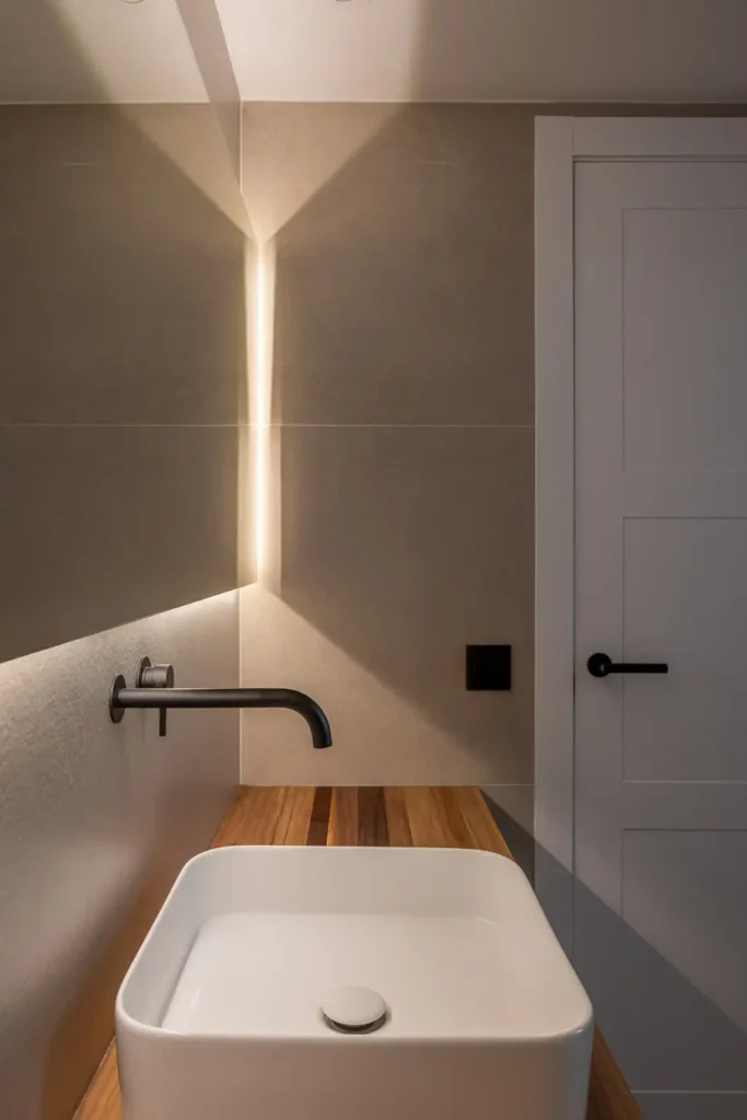 lavabo moderno con iluminacion calida en baño