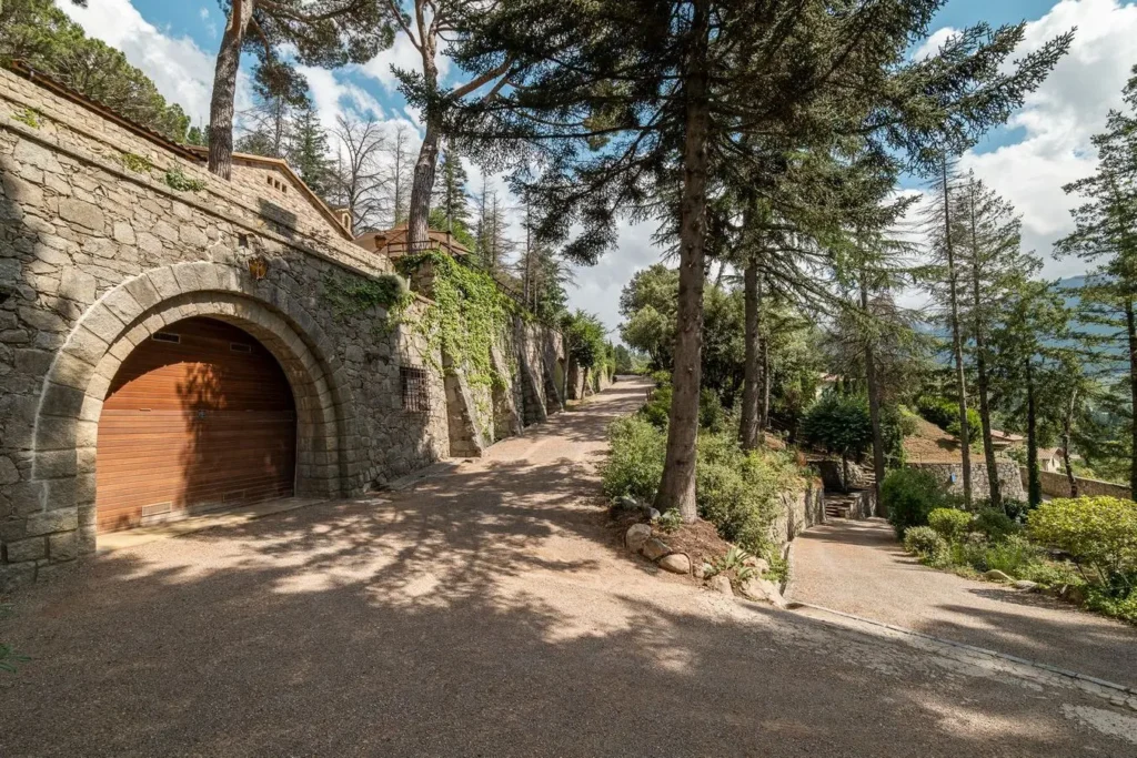 camino exterior con muro de piedra y porton de madera