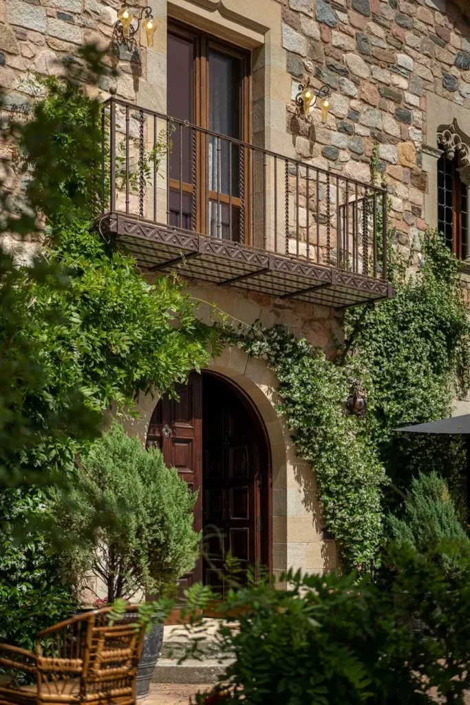 detalle de balcon de hierro y puerta de madera con enredaderas