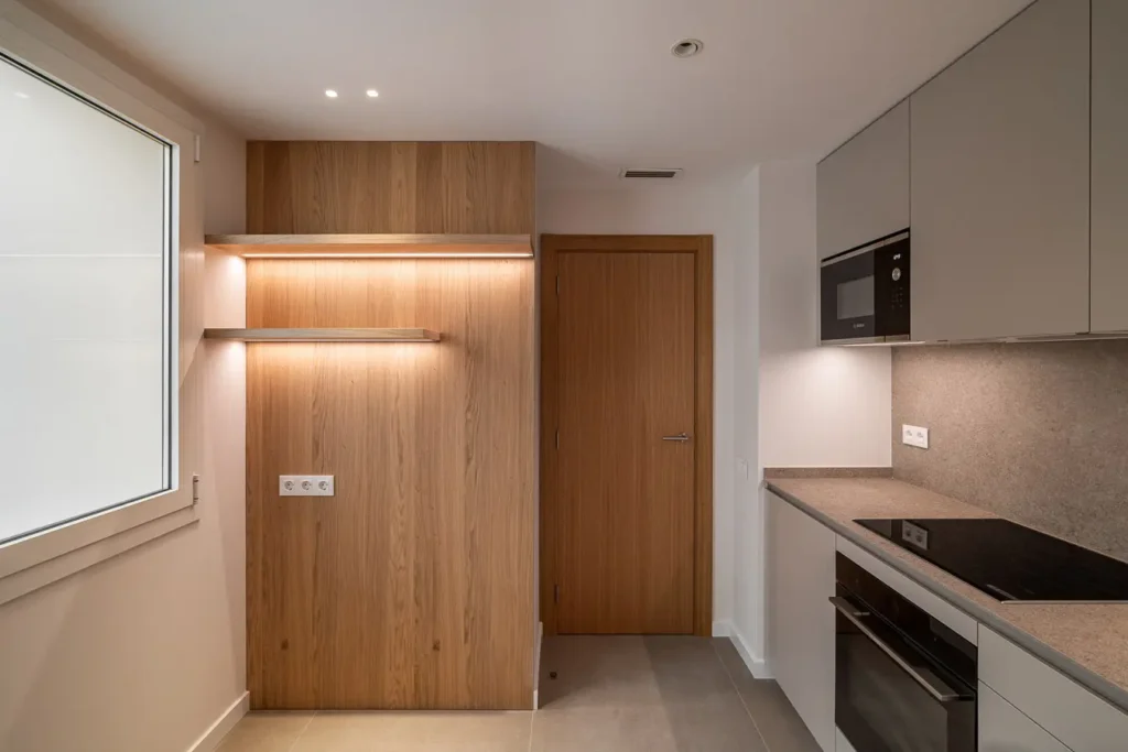 detalles de muebles de cocina con panelado de roble y estantes iluminados