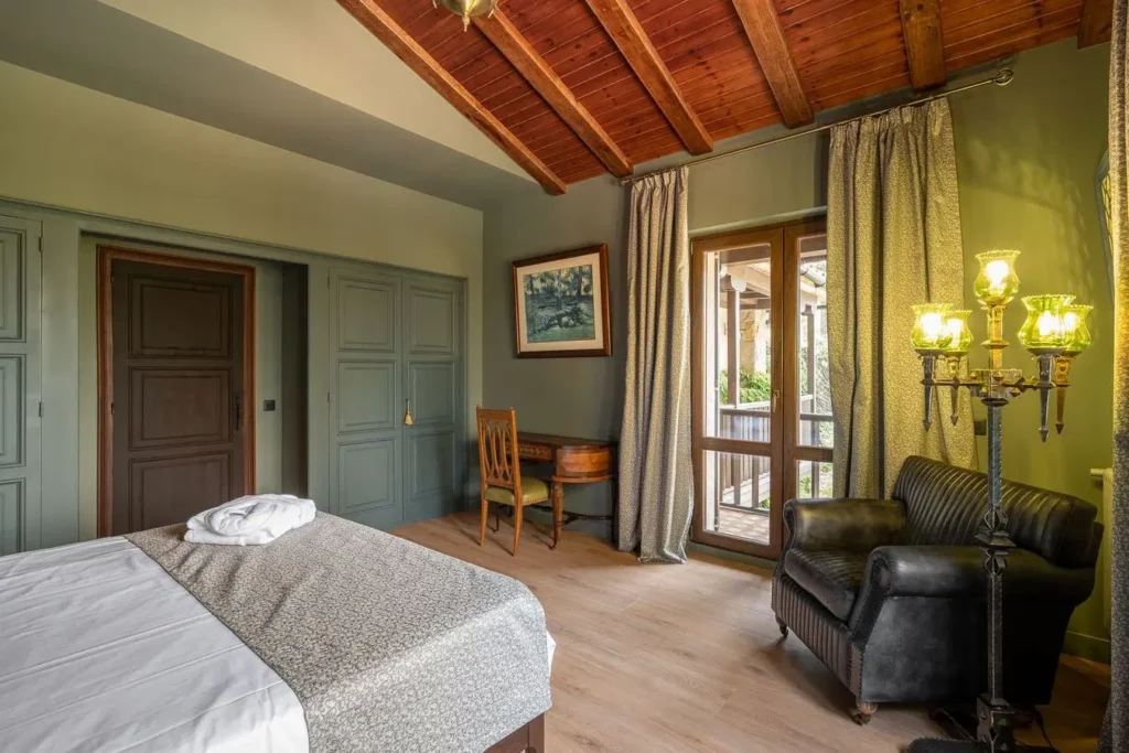 dormitorio con sillón de cuero, escritorio antiguo y lampara clasica