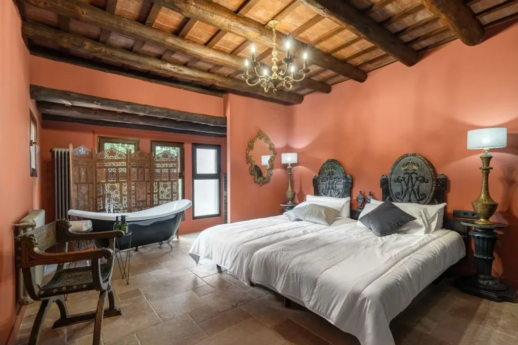 dormitorio con techo de vigas y bano integrado