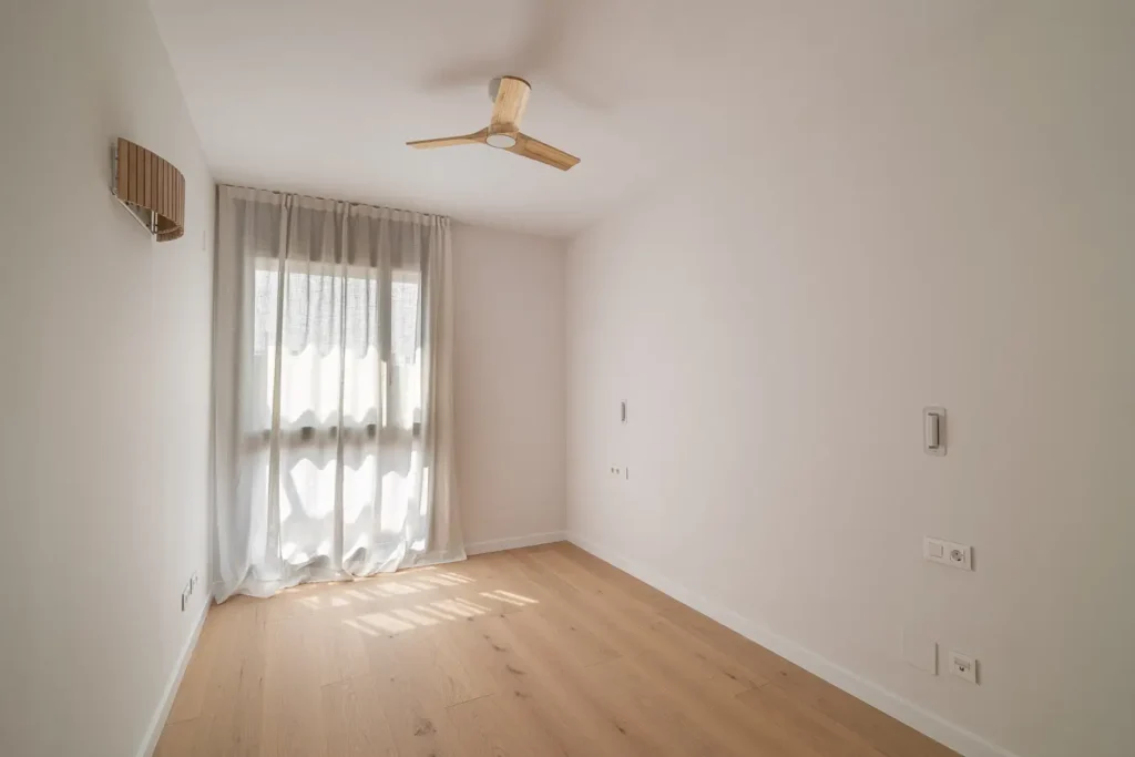 habitacion con ventana cortinas y ventilador de techo de madera