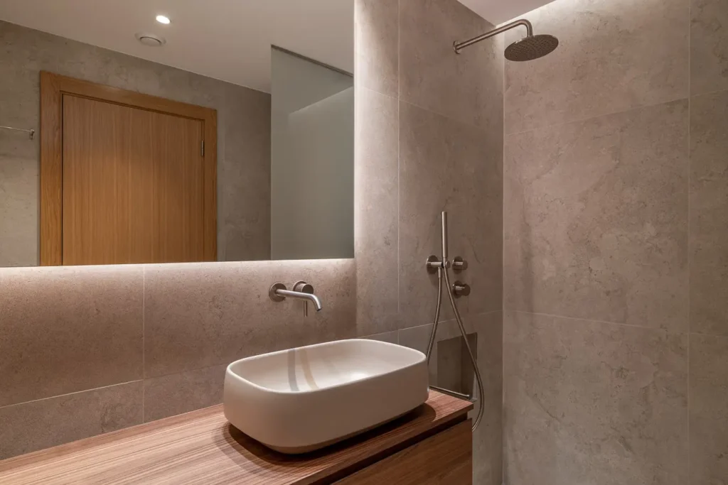 lavabo suspendido con grifo empotrado en bano moderno de piedra