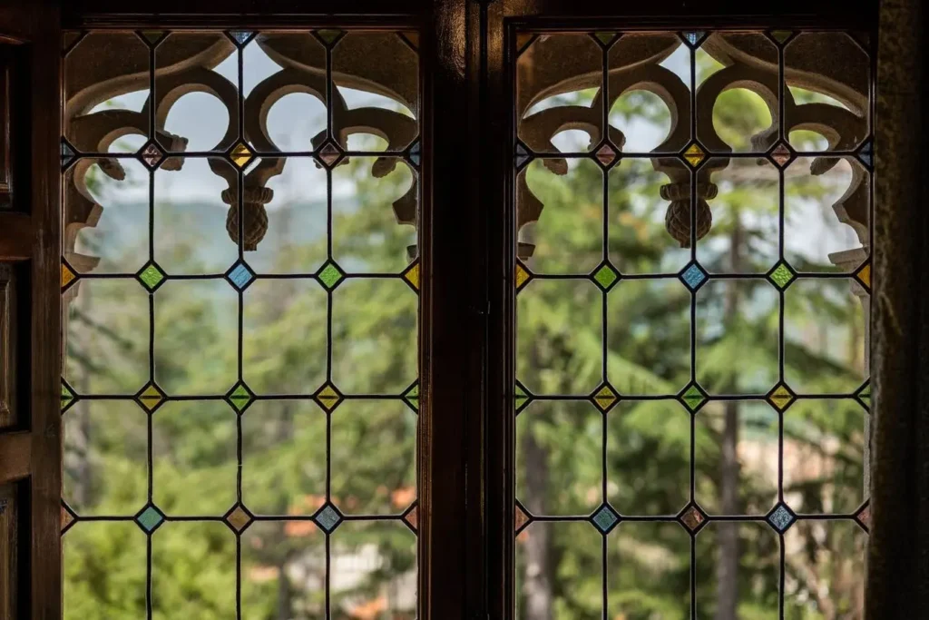 ventana con vidrieras de colores y vista al bosque